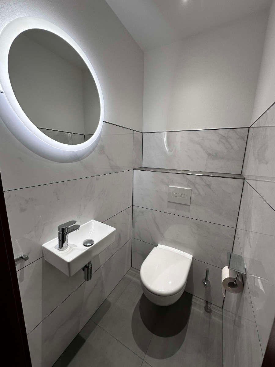 Ein Badezimmer mit Toilette, Waschbecken und Spiegel.