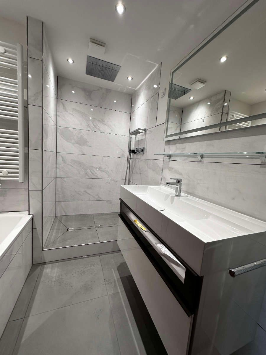 Ein Badezimmer mit Waschbecken, Badewanne, Dusche und Spiegel.