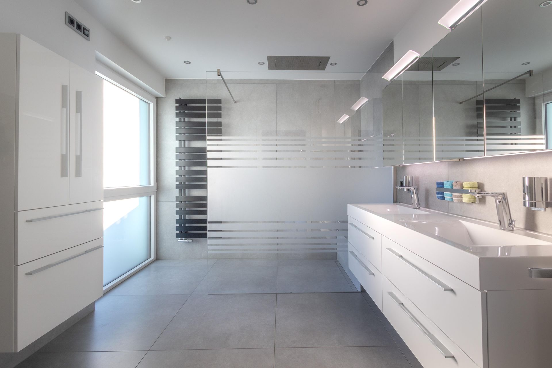 Ein Badezimmer mit zwei Waschbecken und einem großen Fenster