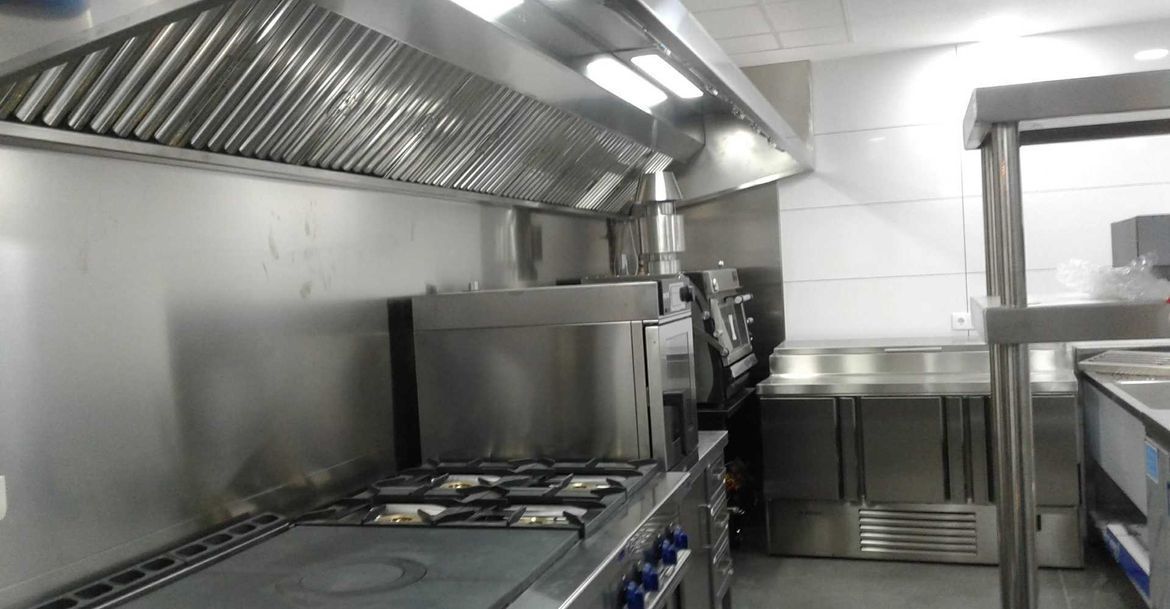 Una cocina con electrodomésticos de acero inoxidable y un horno de estufa.