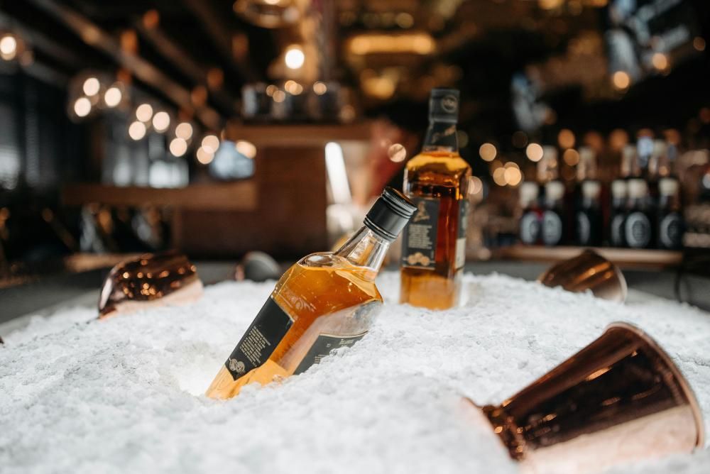 Bouteilles de whisky déposées sur de la glace pilée