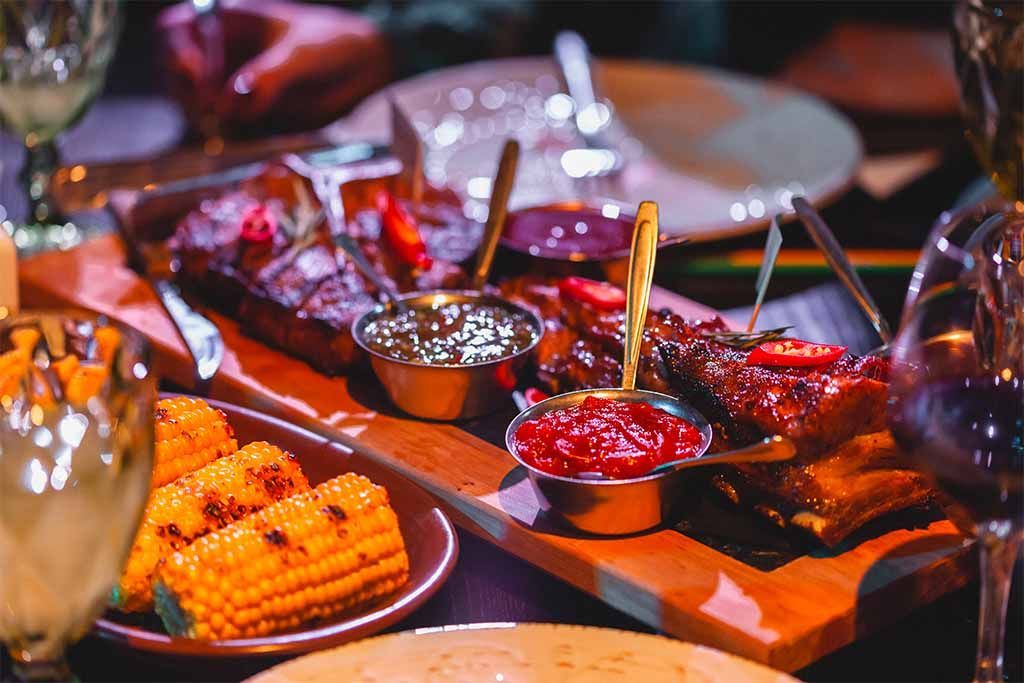 Viandes et sauces sur un plateau, à table