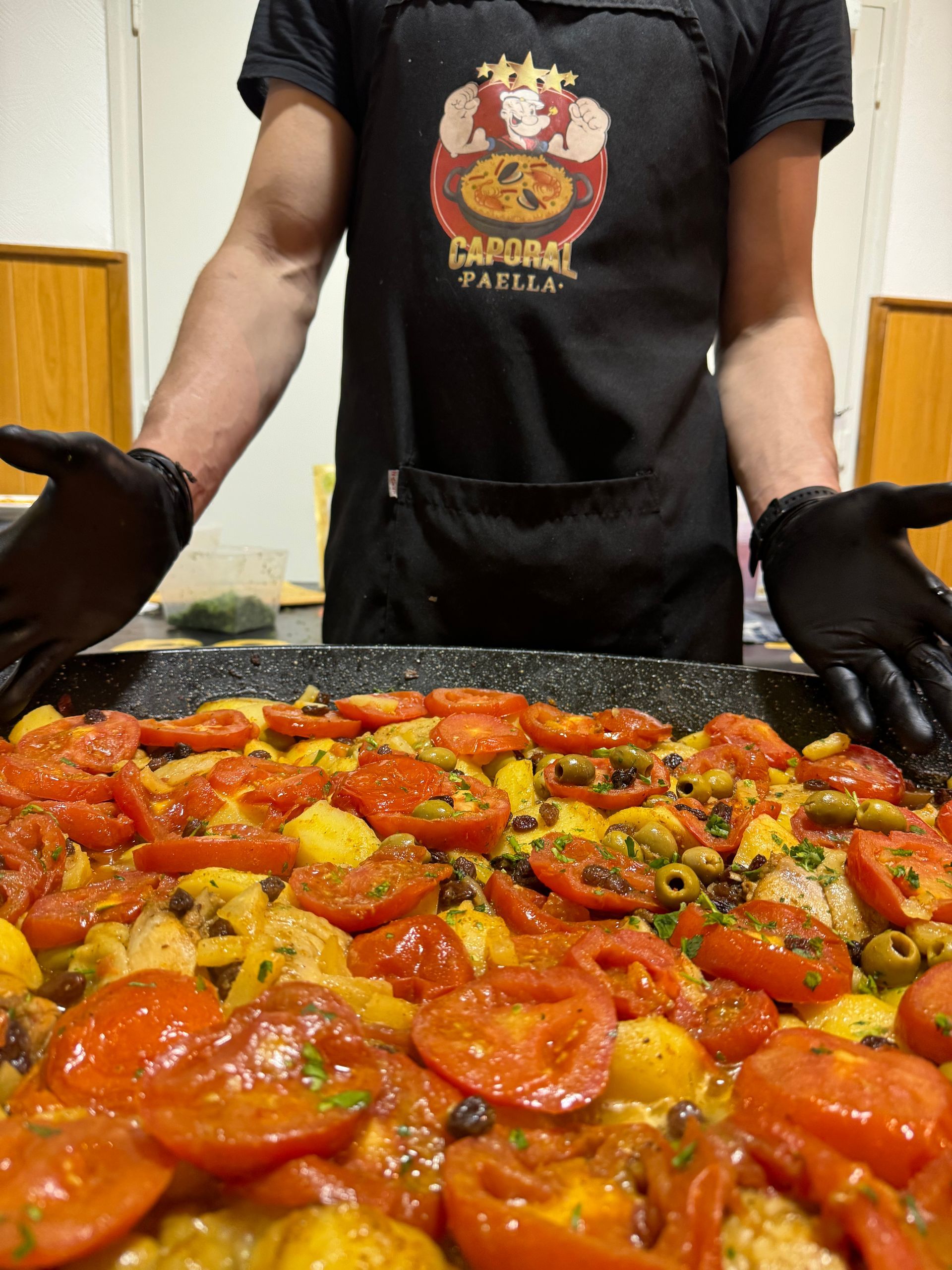 Plat de paella avec le chef derrière