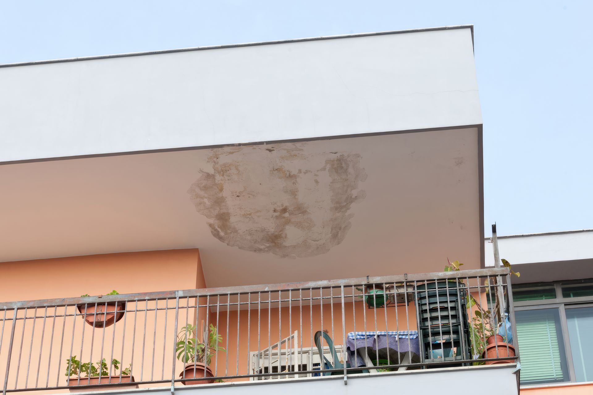 Balcon d'appartement avec taches d'humidité sur le plafond