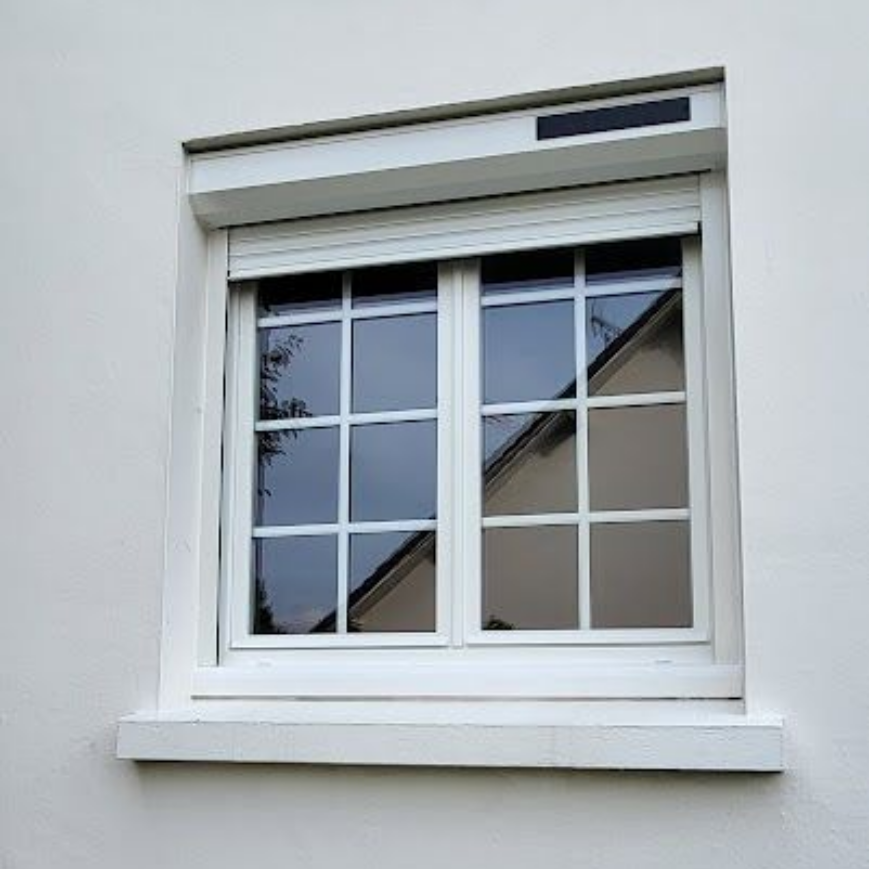 Maison en briques avec toit gris, fenêtres et pignons à ossature bois claire.