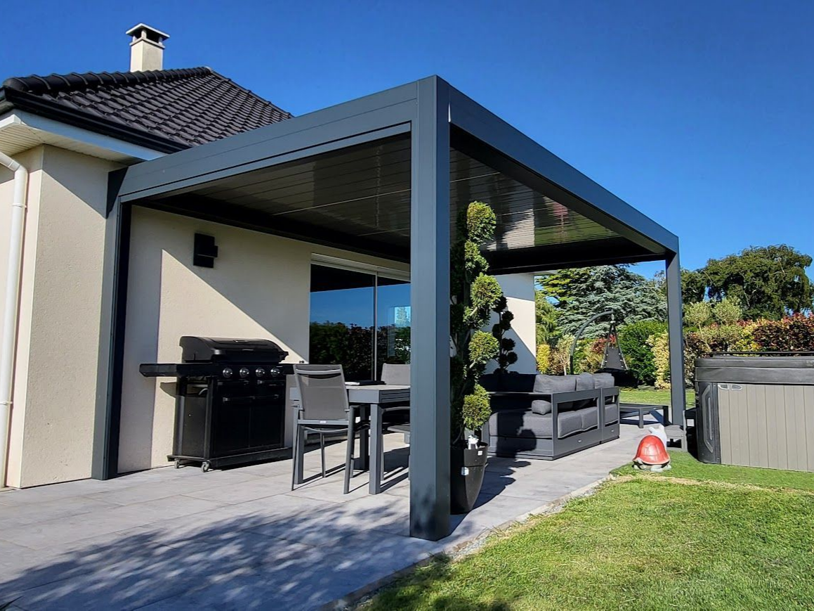 Une terrasse extérieure moderne avec une pergola grise, un barbecue, un ensemble repas et des sièges par une journée ensoleillée.