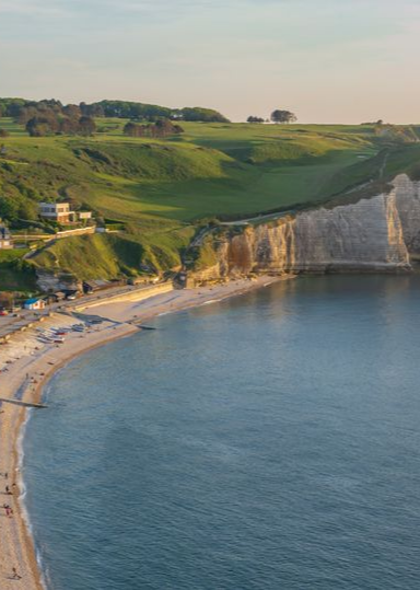 Patio avec toit en pergola grise, mobilier de jardin et vue sur la verdure et le ciel bleu.