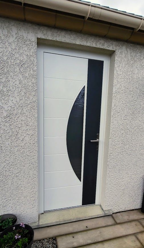 Porte blanche ornée d'un ovale noir et d'une rayure verticale, sur un mur clair texturé.