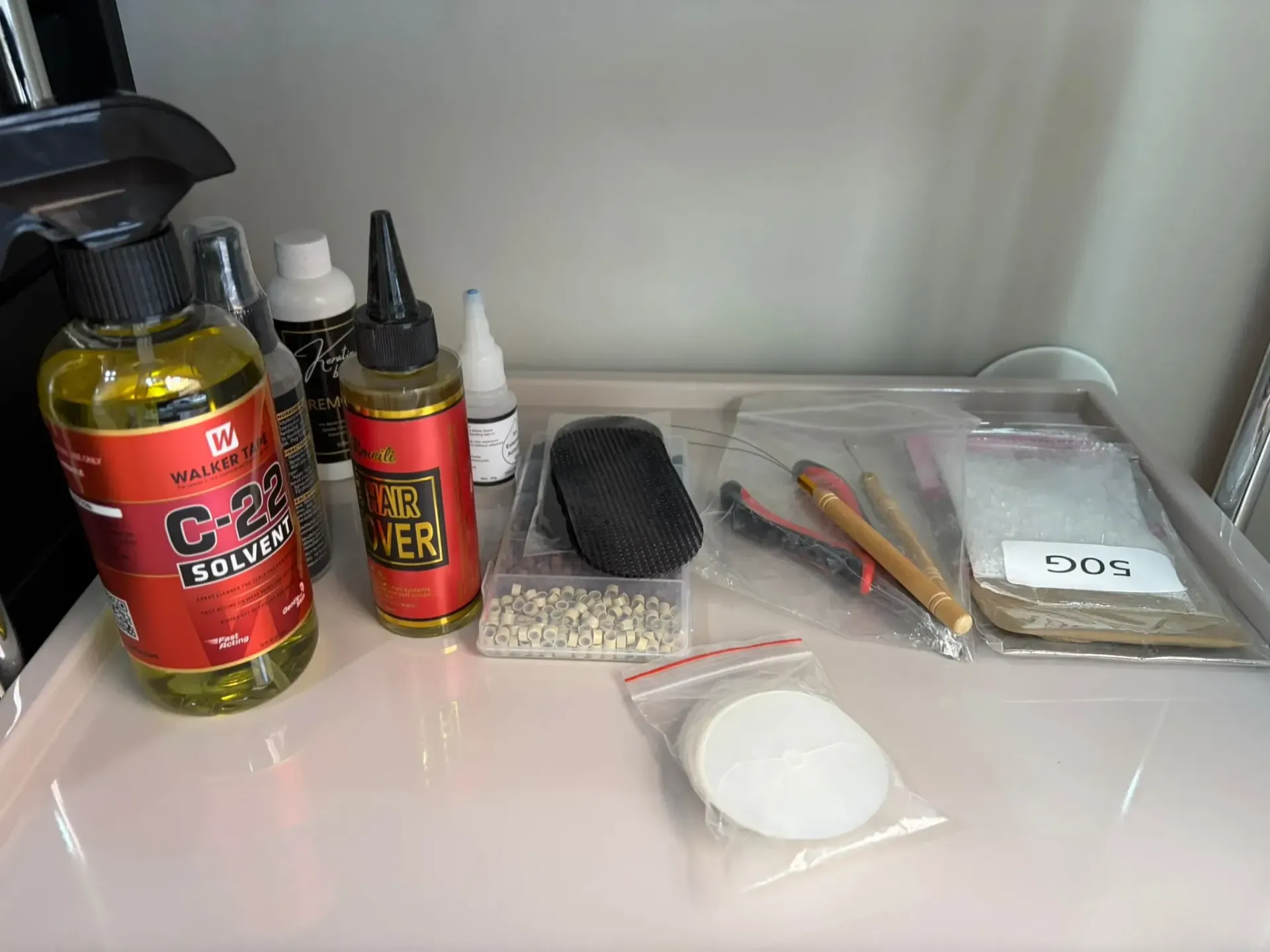 Un estante con botellas, una botella de spray, bolsas pequeñas y herramientas.