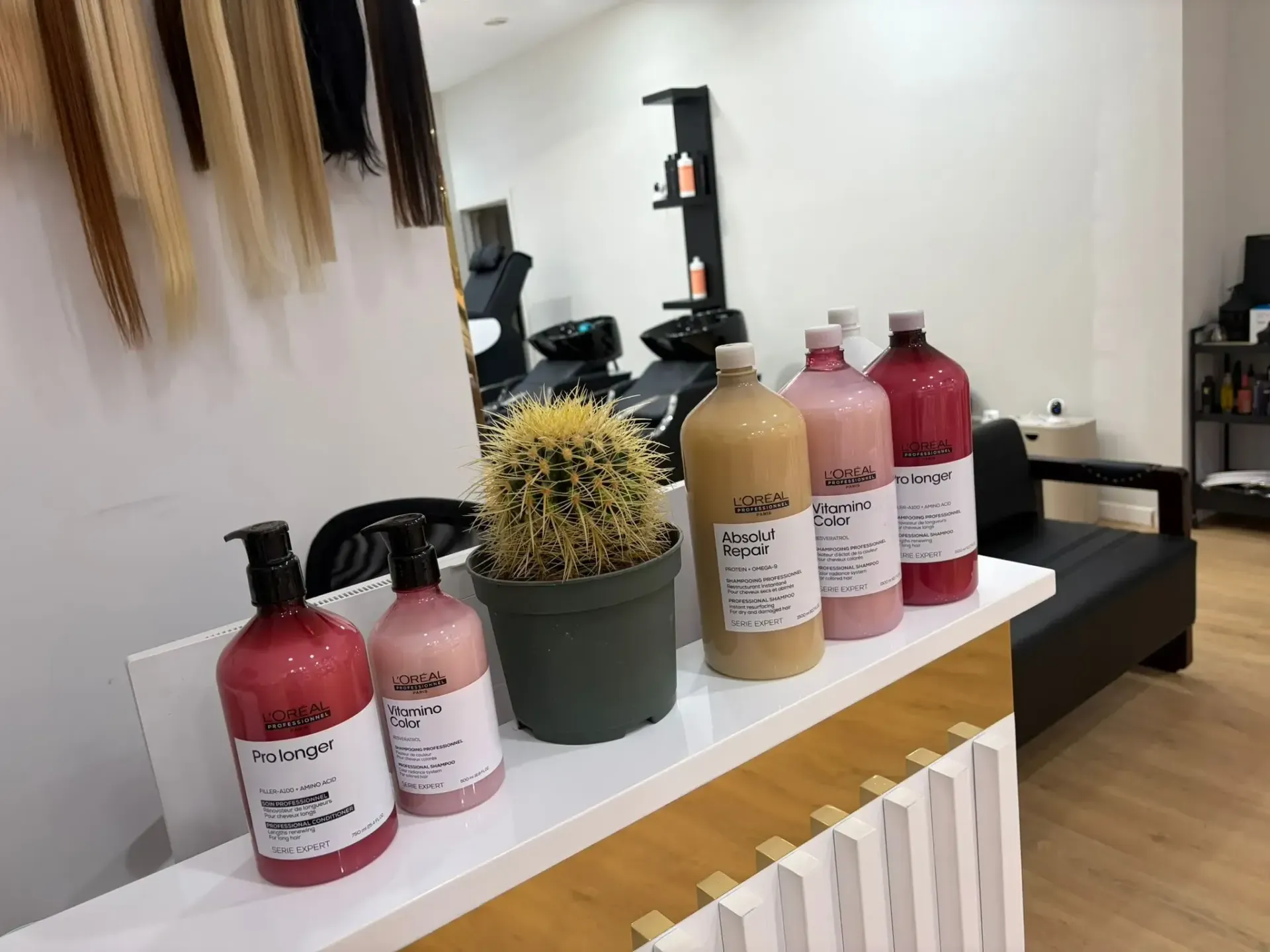 Interior de peluquería con botellas de producto y extensiones de cabello.