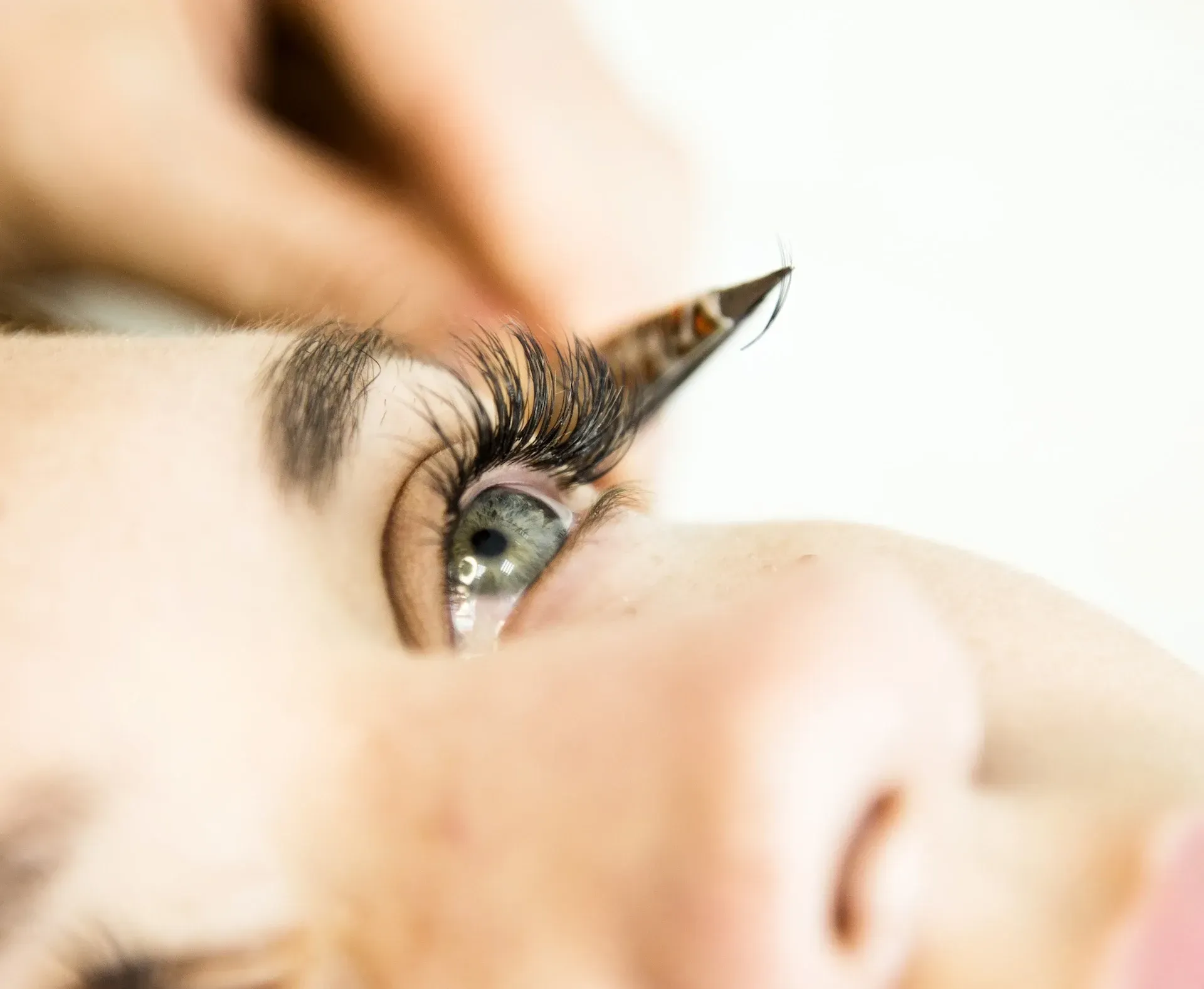 Ojo con extensiones de pestañas aplicadas con pinzas.