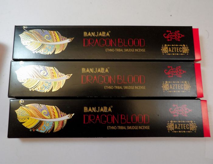 Tres cajas apiladas de incienso Banjar Dragon Blood, negras y rojas con ilustraciones de dragones dorados y la marca azteca.