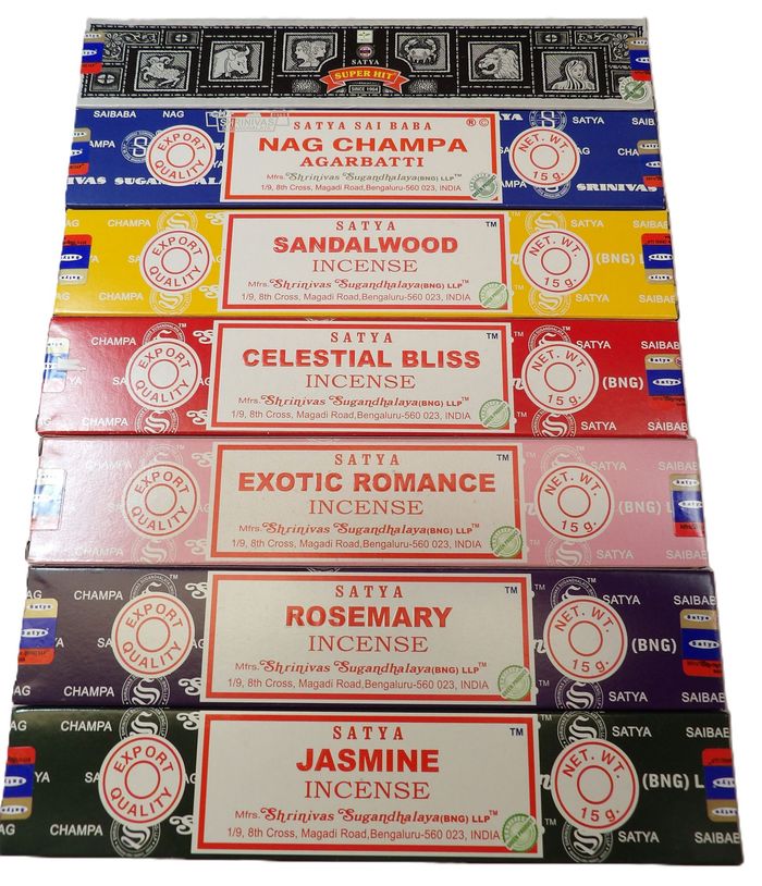 Cajas de incienso apiladas y coloridas con etiquetas florales: Nag Champa, Sándalo, Felicidad Celestial, Romance Exótico, Romero, Jazmín.