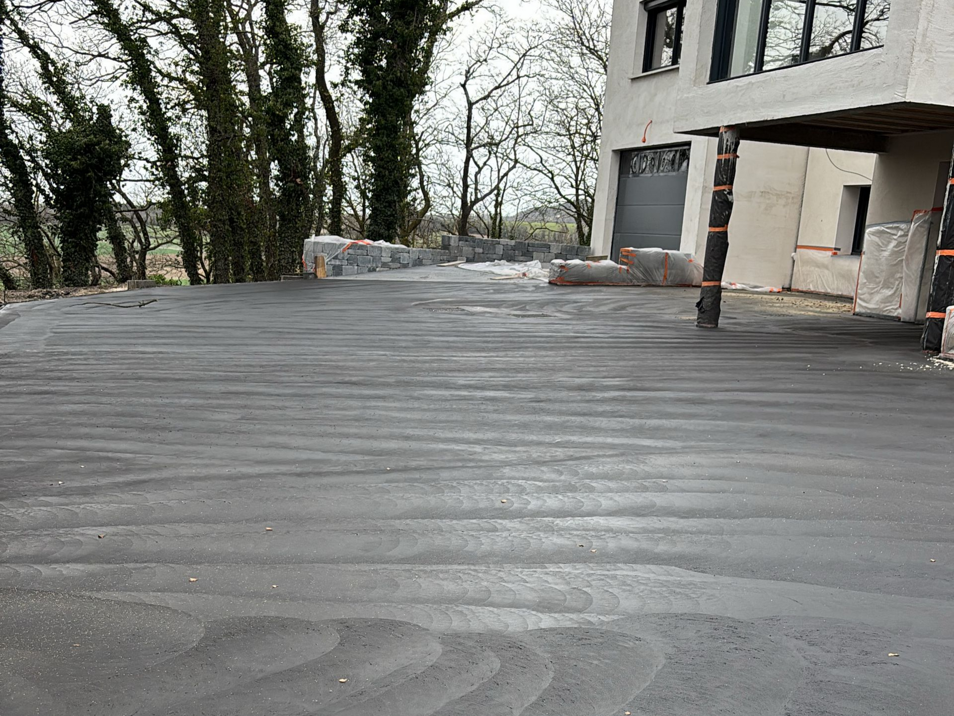 Cour en béton gris foncé posé devant un bâtiment moderne.