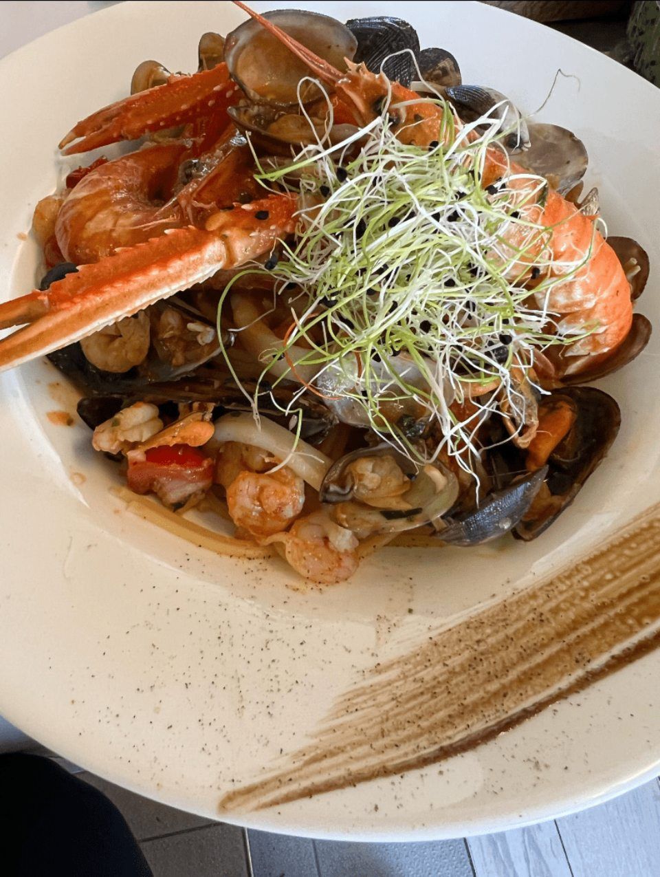 Un gros plan d'une assiette de nourriture avec des crevettes et des palourdes sur une table.