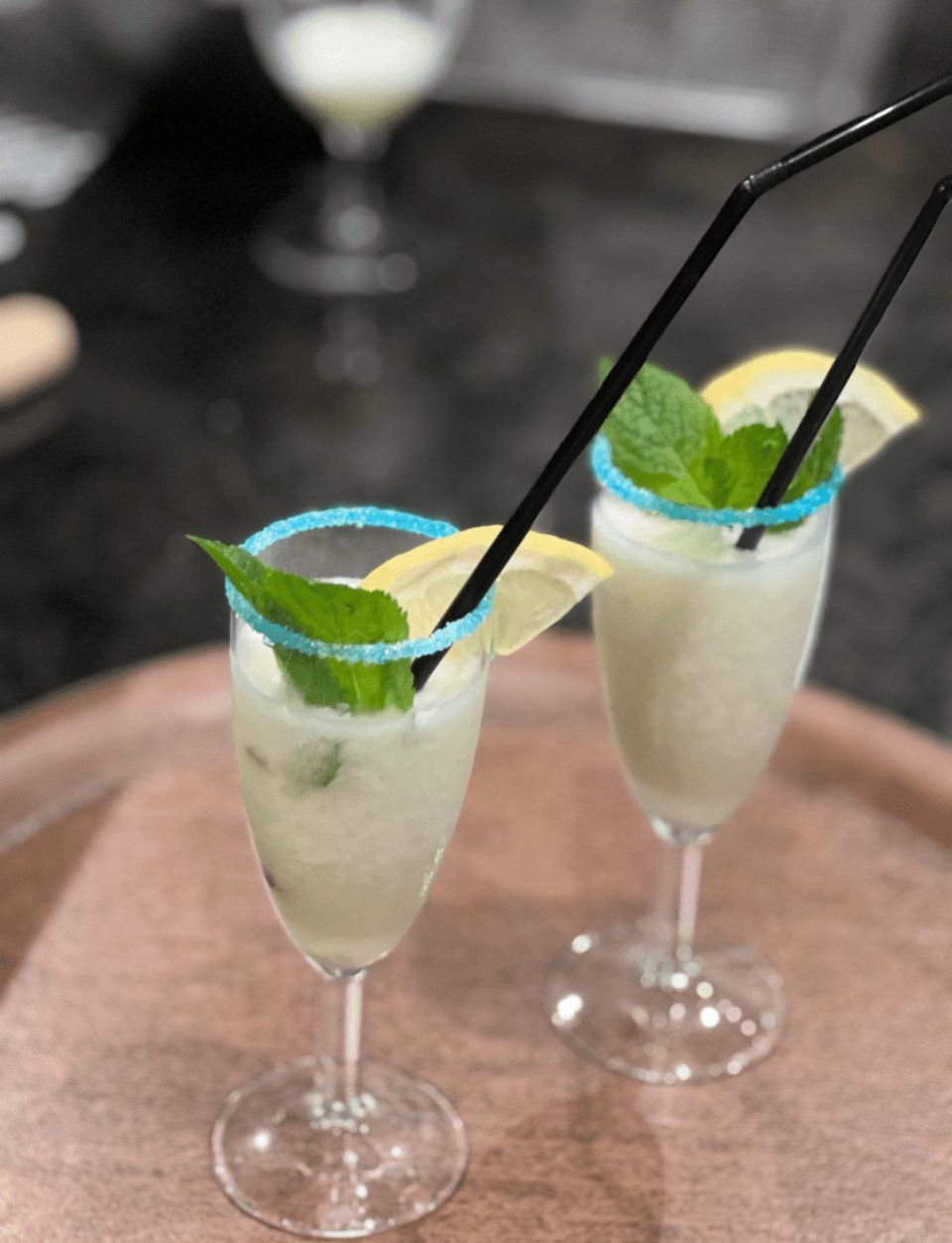 Deux boissons avec des pailles et des feuilles de menthe sur un plateau