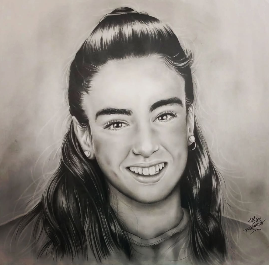 Retrato en blanco y negro de una persona joven sonriente, con el pelo largo recogido en una coleta alta