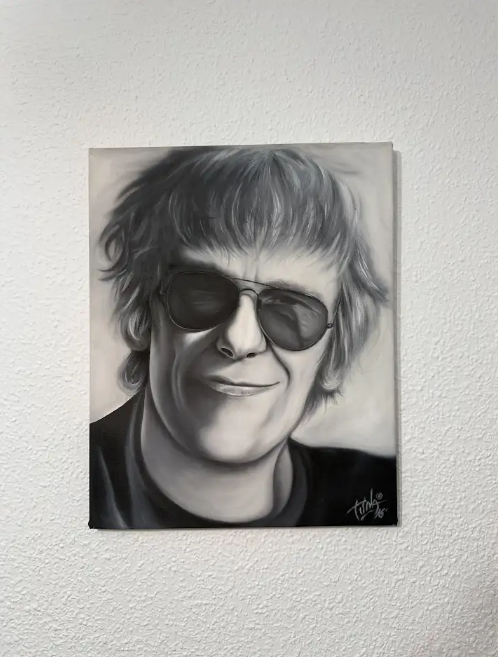 Retrato en primer plano en escala de grises de una persona sonriente con gafas de sol oscuras