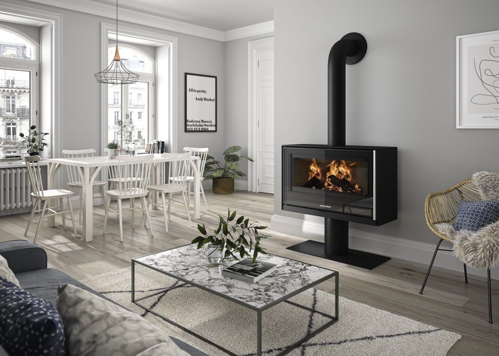 Salon moderne gris avec cheminée noire, table à manger blanche et table basse en verre