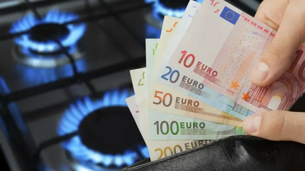 Eine Person hält einen Stapel Euroscheine vor einem Gasbrenner