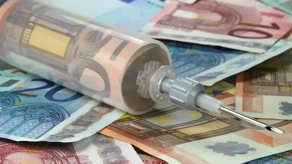 Eine Spritze liegt auf einem Haufen Geld