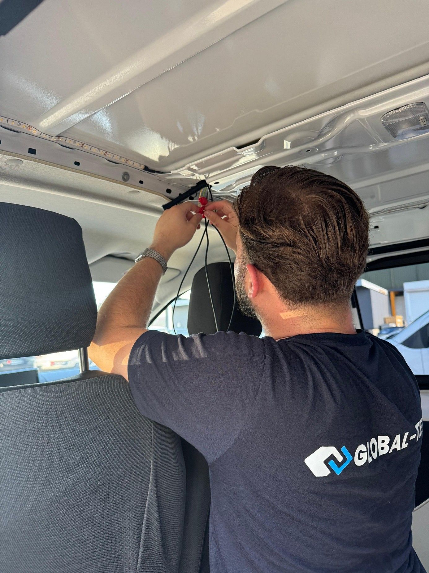 Innenraum eines weißen Lieferwagens mit Regalen, Schubladen und Lagerbehältern.