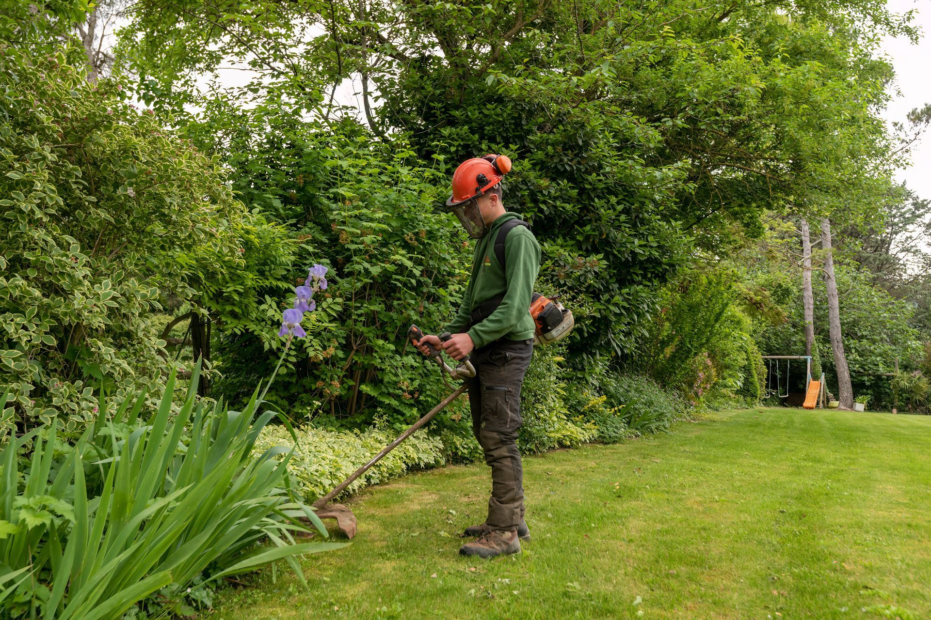 Paysagiste avec un casque orange en intervention