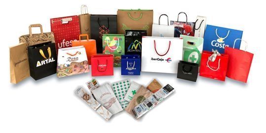Se muestran una variedad de bolsas de papel y folletos sobre un fondo blanco.