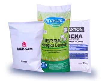 Tres bolsas de tierra están colocadas una al lado de la otra sobre una superficie blanca.