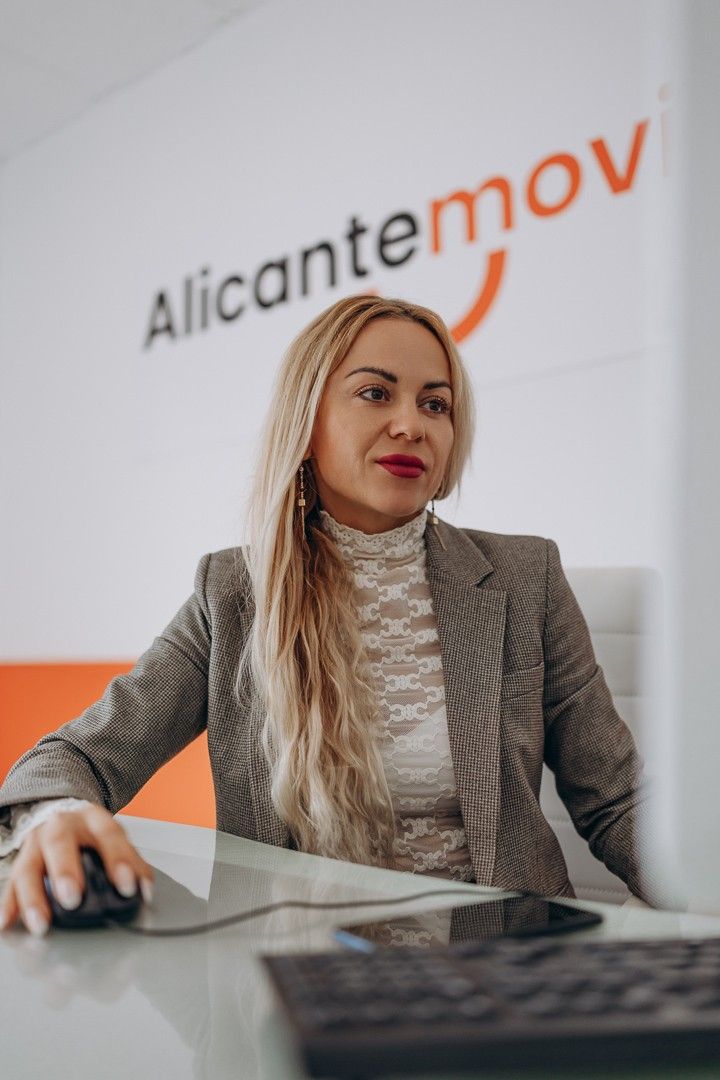 Avión en la puerta del aeropuerto durante la puesta de sol, con carros de equipaje y un cielo resplandeciente de colores.