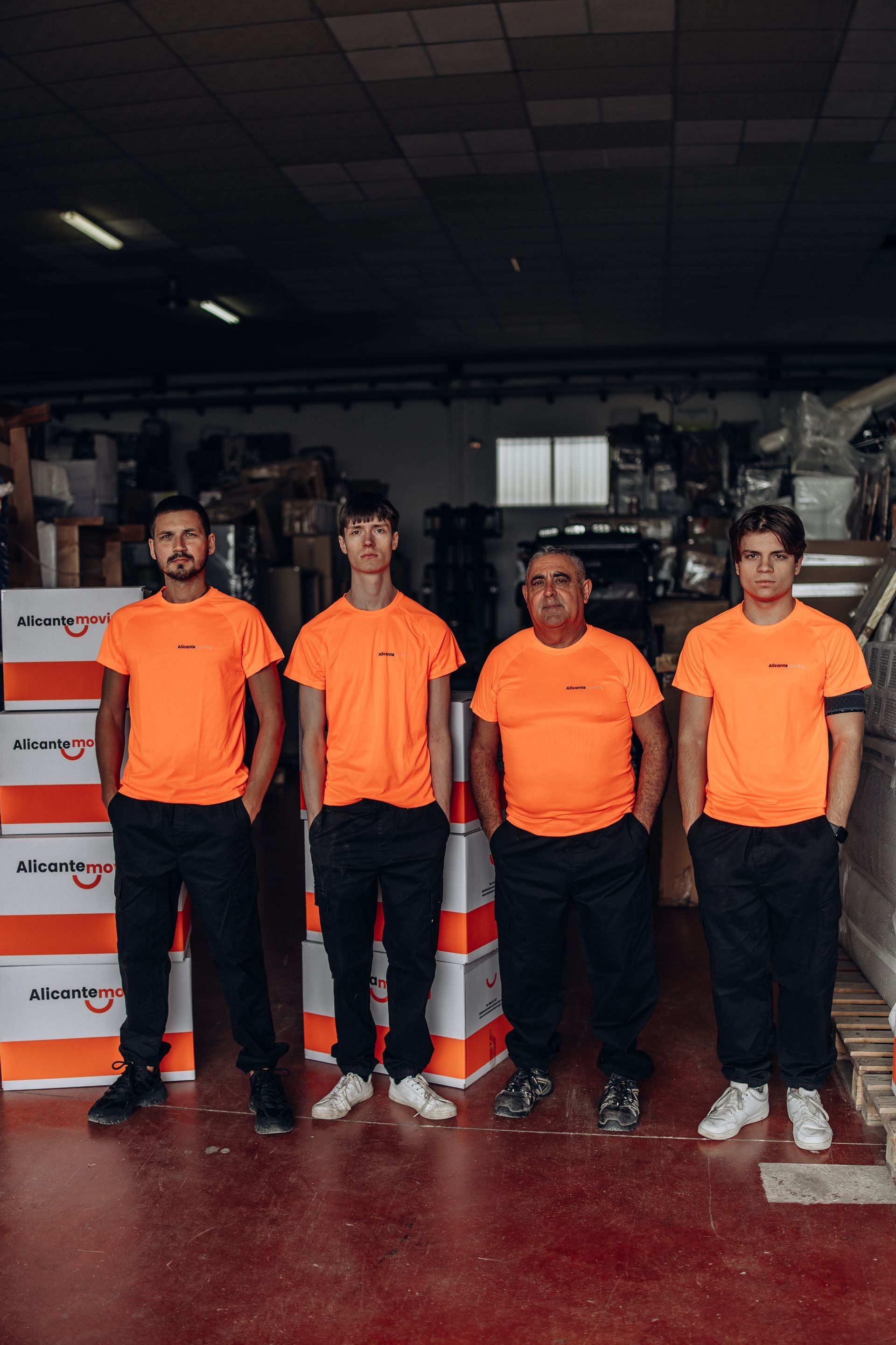 Paseo marítimo con palmeras, edificios y una gran estructura rocosa con un edificio moderno en Alicante, España.