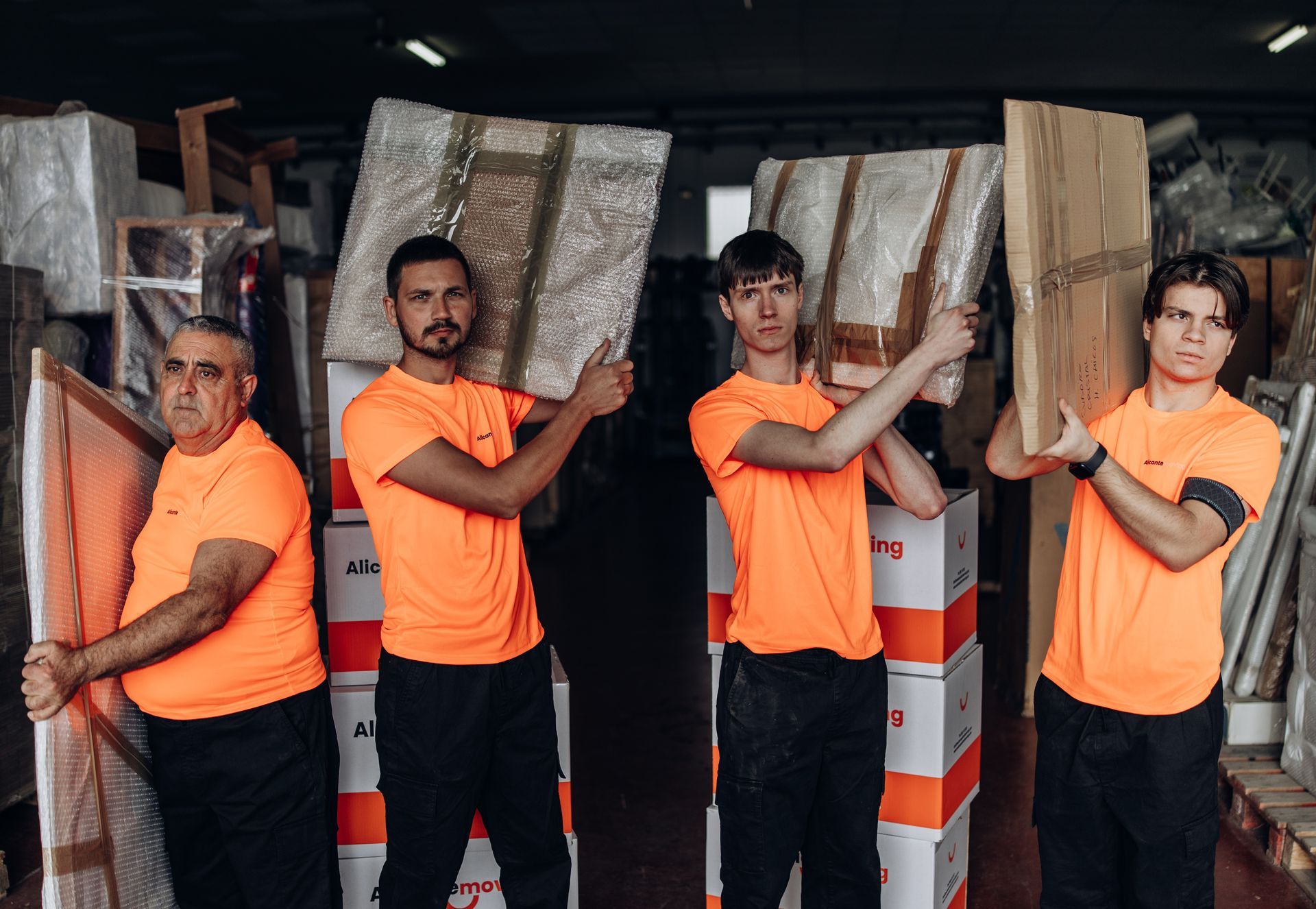 Paseo marítimo con palmeras, edificios y una gran estructura rocosa con un edificio moderno en Alicante, España.