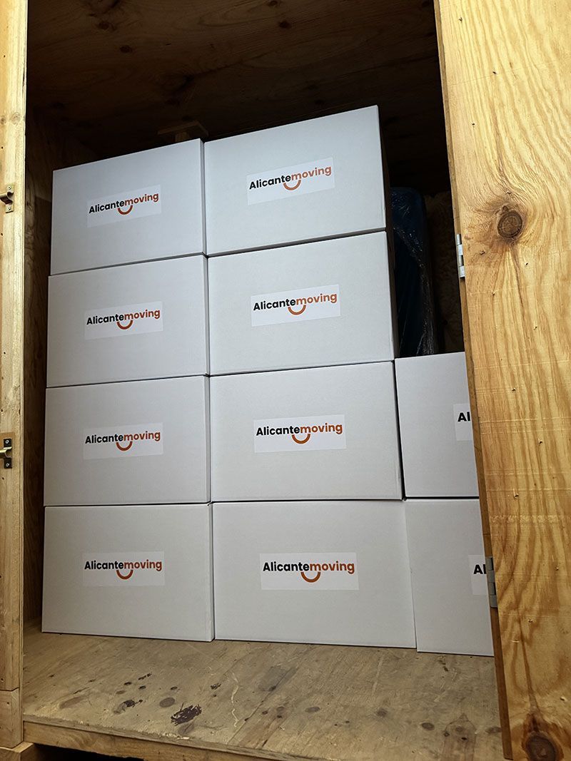 Mano que alcanza una caja de cartón en un estante de un almacén.