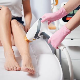 Una mujer está recibiendo un tratamiento de depilación láser en las piernas.