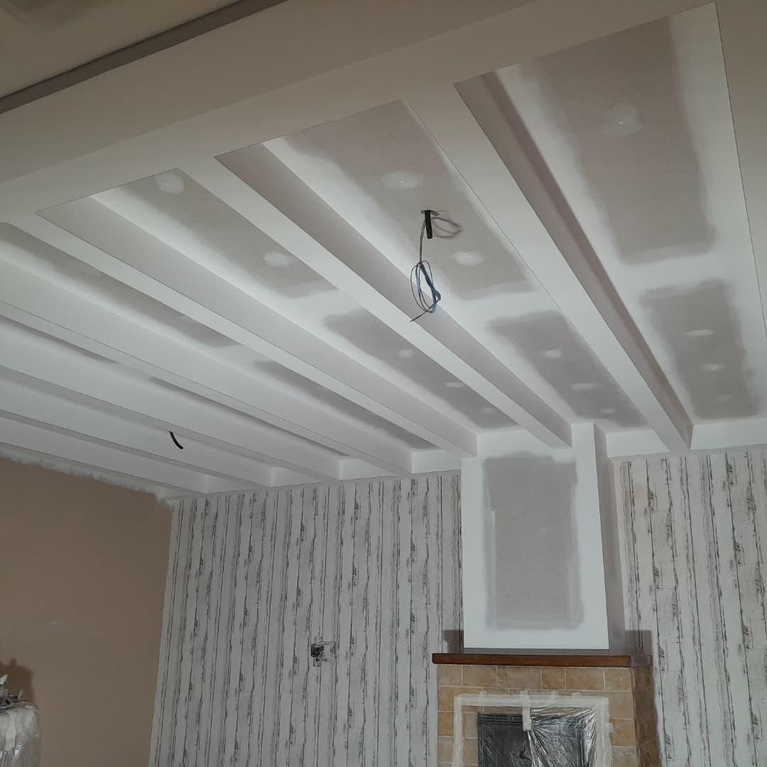 Una habitación con techo artesonado, paredes de pladur parcialmente terminadas