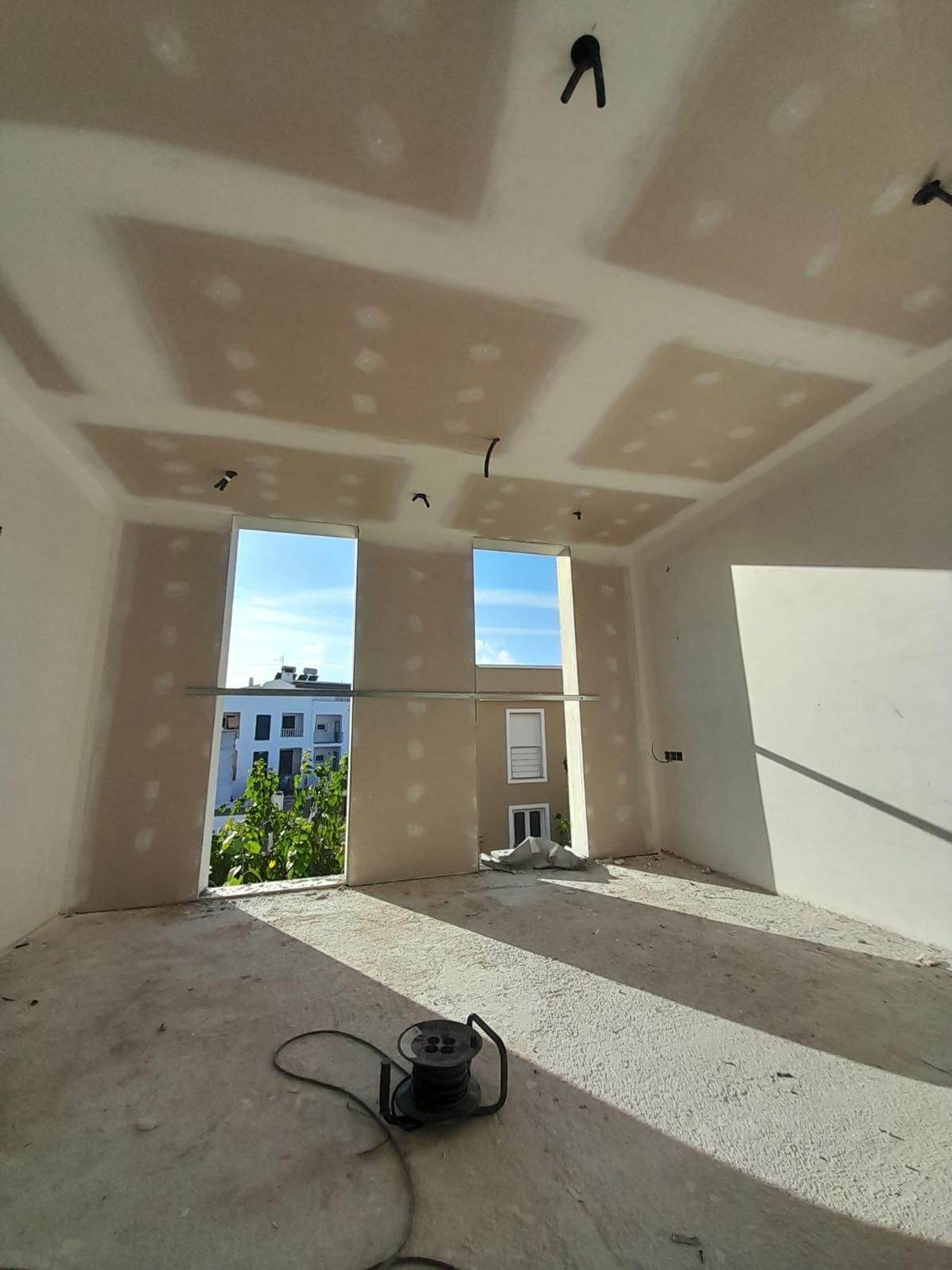 Una habitación interior en construcción con paredes de pladur al descubierto, juntas selladas