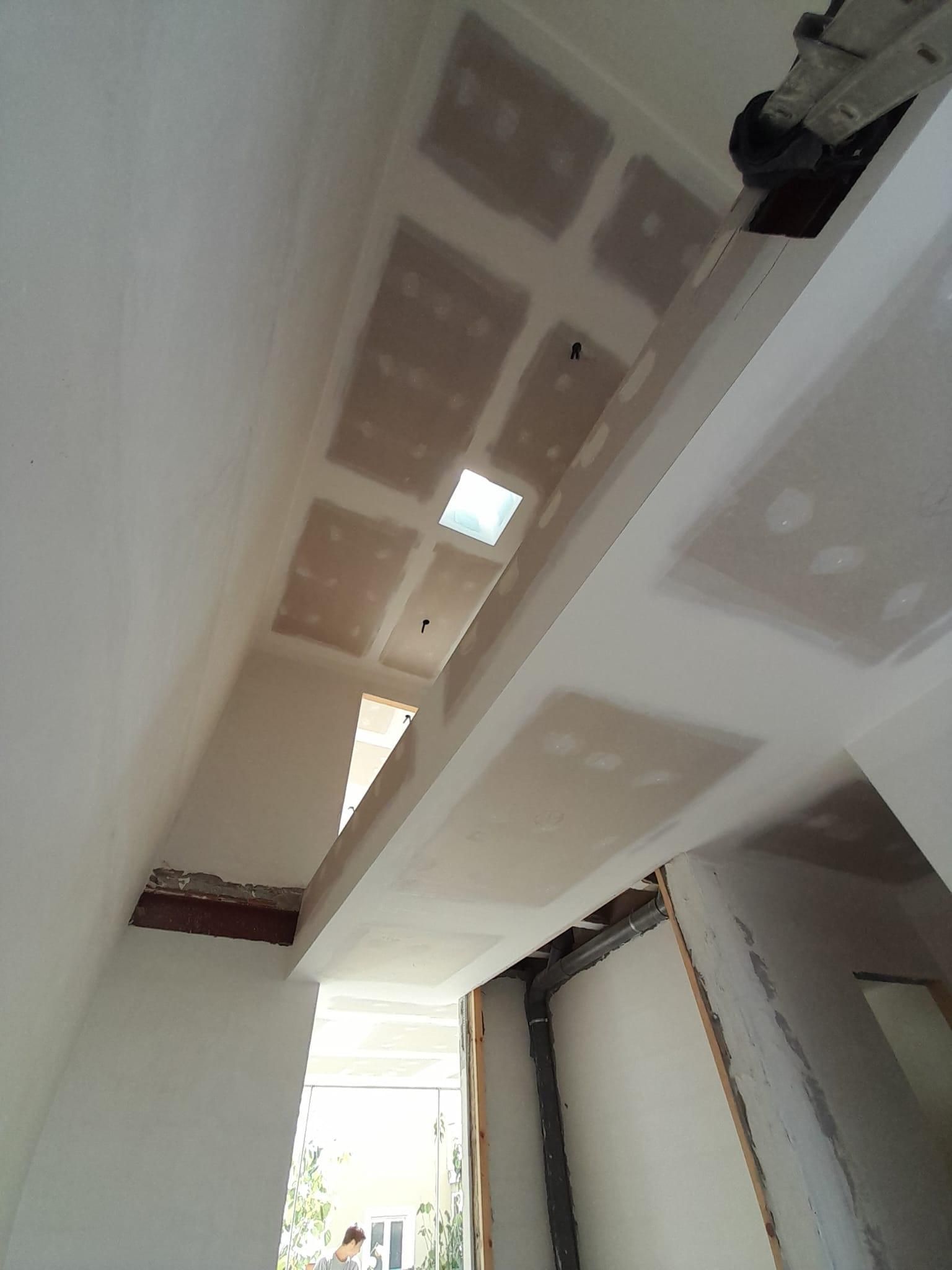 Vista desde un ángulo bajo de una habitación en construcción con techos de pladur blanco