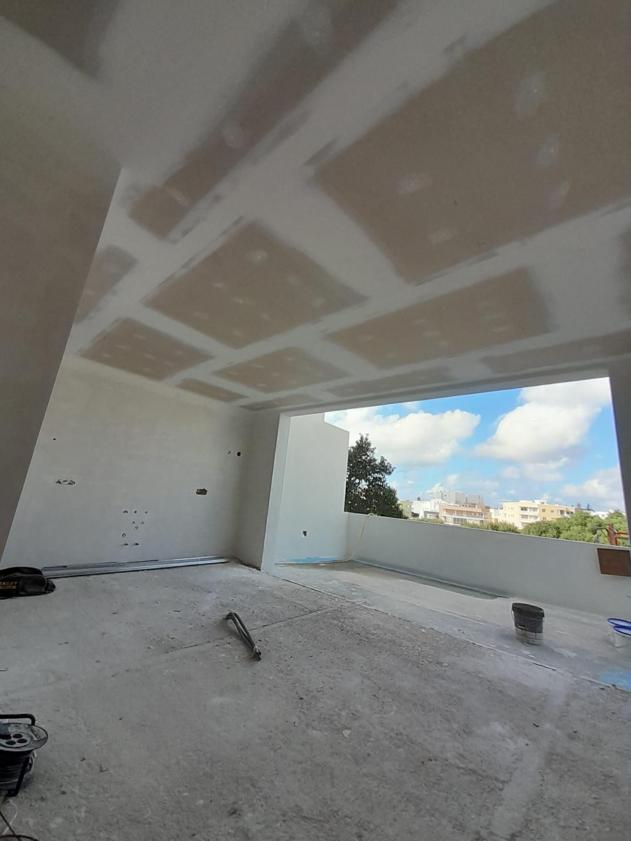 Una habitación interior en construcción con paneles de yeso sellados en el techo y las paredes