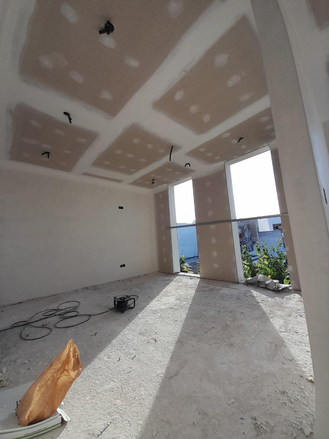 Vista interior de una habitación en construcción con paneles de yeso y techo terminados