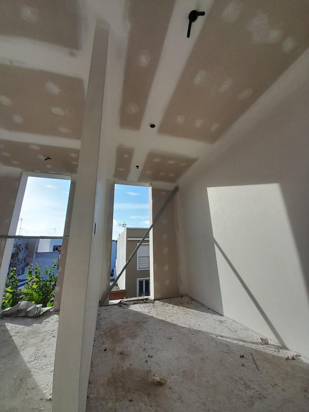 Vista interior de una habitación en construcción con techos de pladur blanco