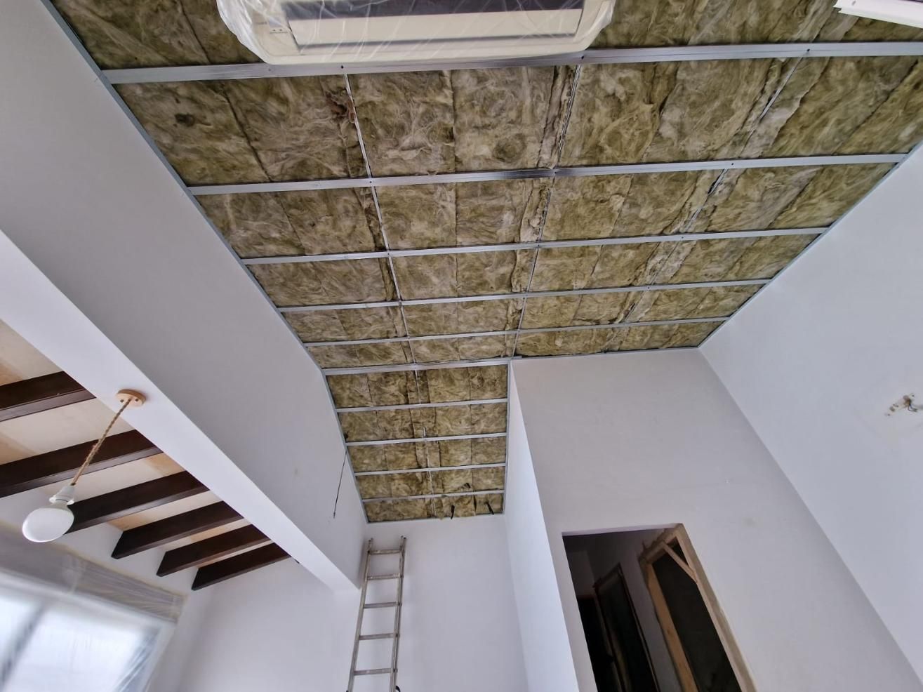 Instalación de techo parcialmente terminada que muestra una estructura metálica rellena