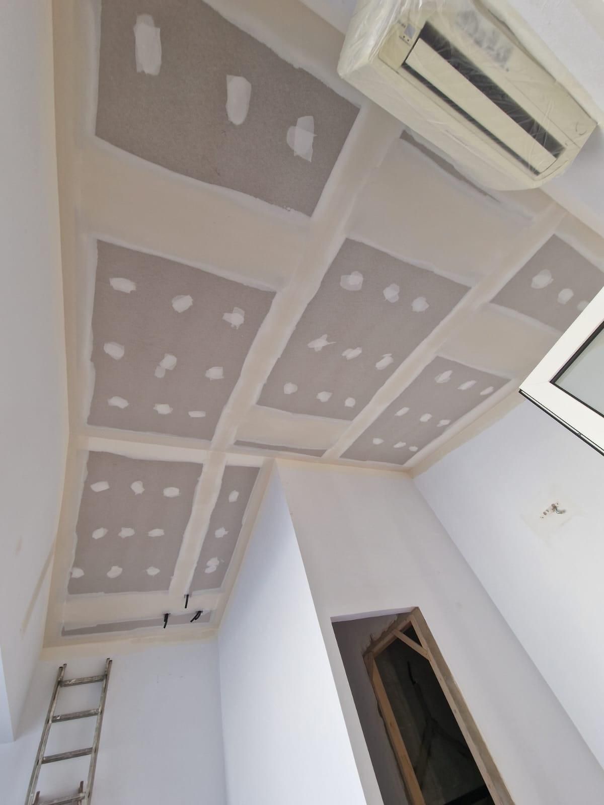 Vista desde un ángulo bajo del techo de una habitación con paneles de yeso instalados