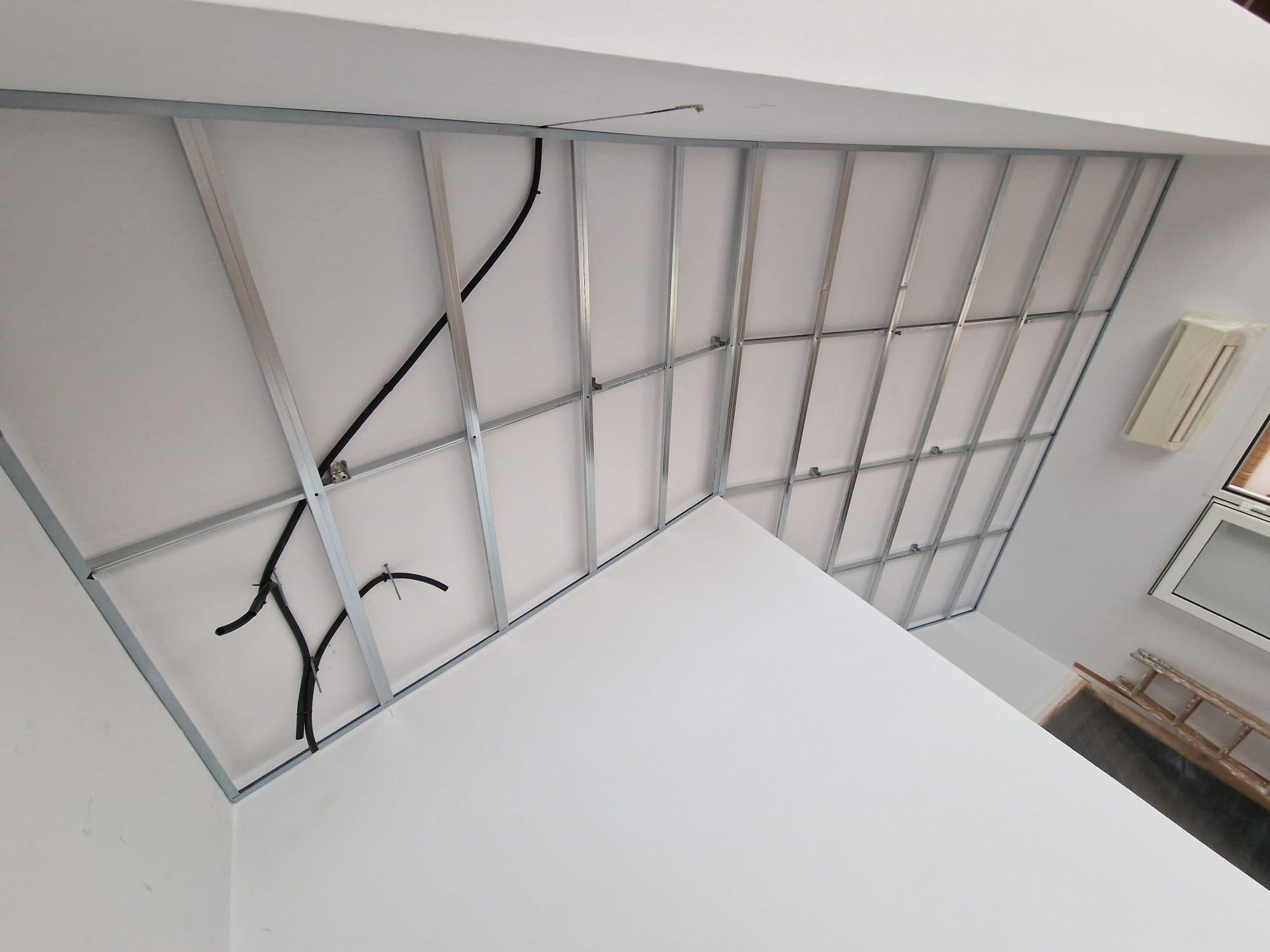 Vista interior del techo que muestra una estructura metálica para la instalación de paneles de yeso