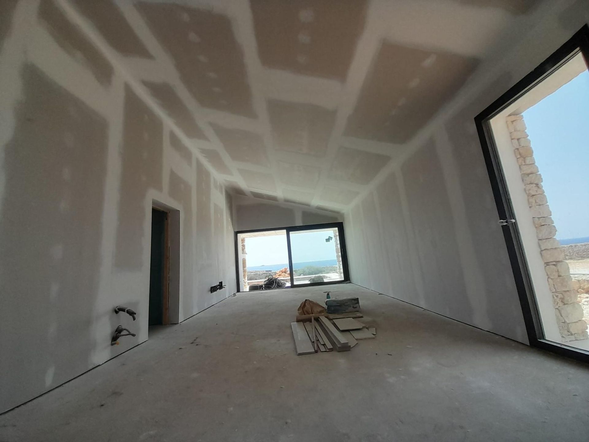 Vista interior de una habitación en construcción con paredes y techo de pladur sin terminar