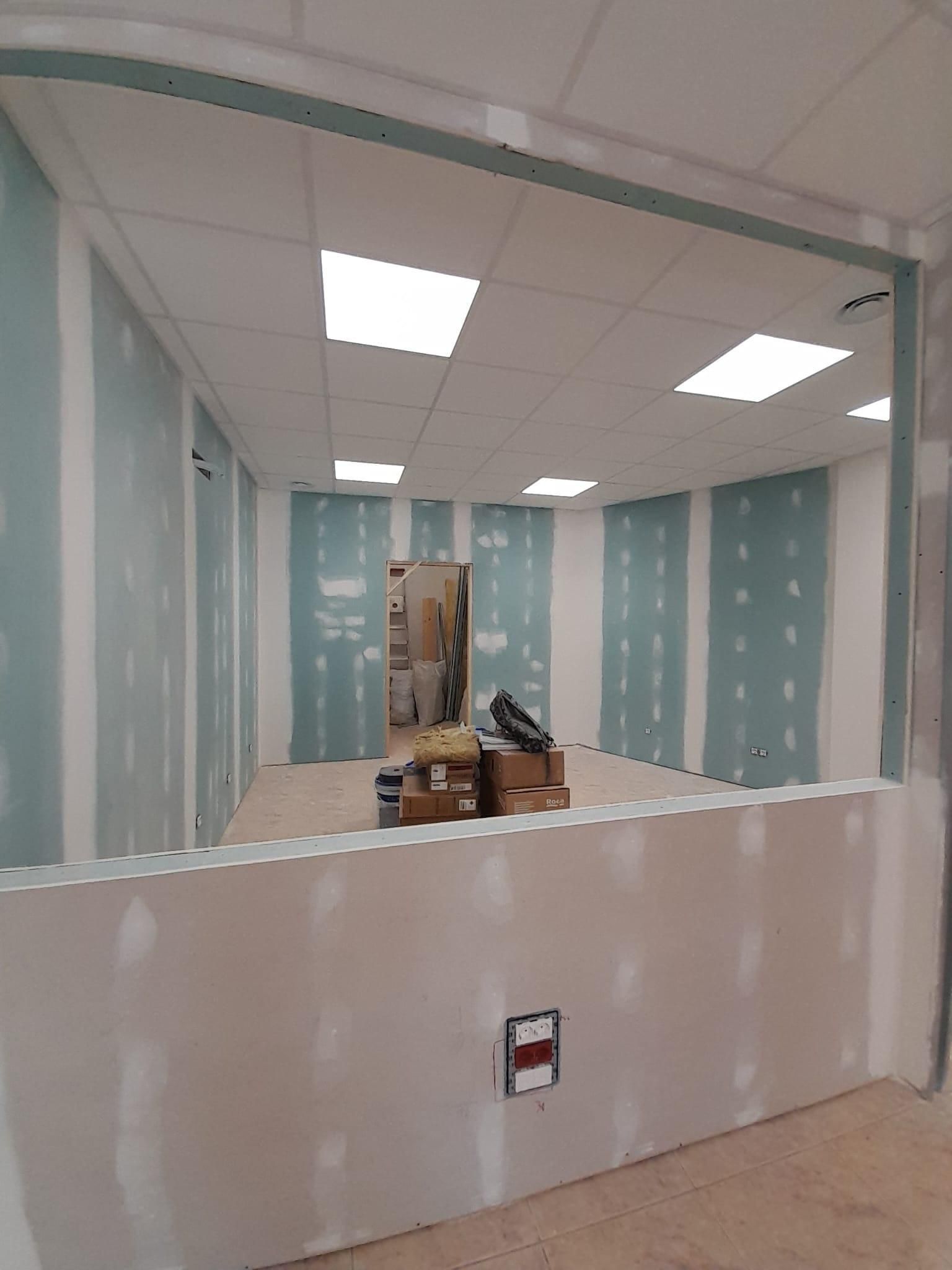 Interior de una oficina en construcción, con paredes parcialmente revestidas de pladur.