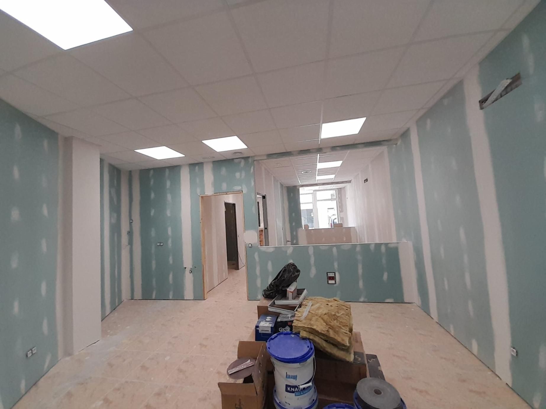 Interior de una habitación en construcción con paneles de yeso azul claro, juntas selladas con cinta blanca