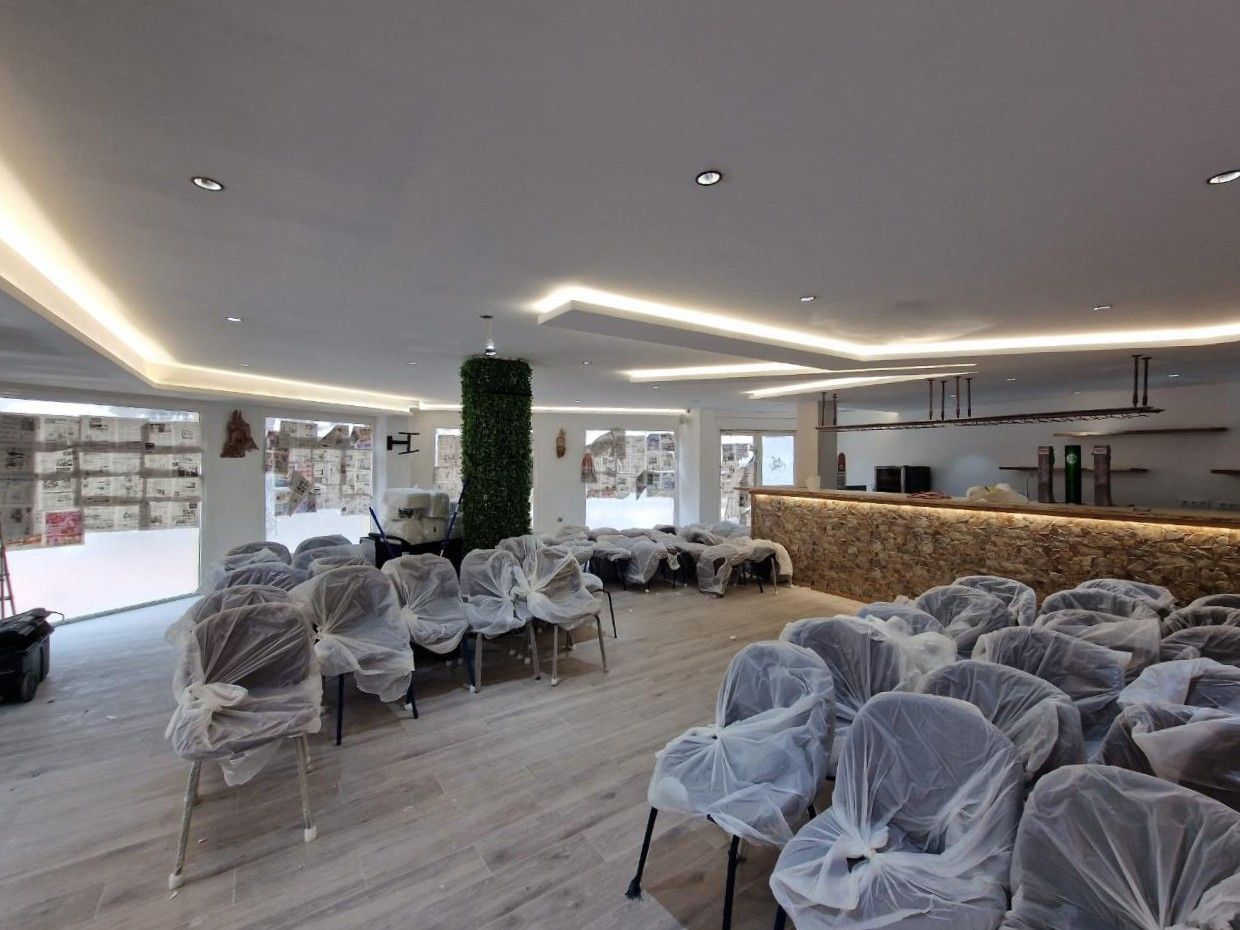 Un espacio para eventos moderno con filas de sillas cubiertas con plástico protector