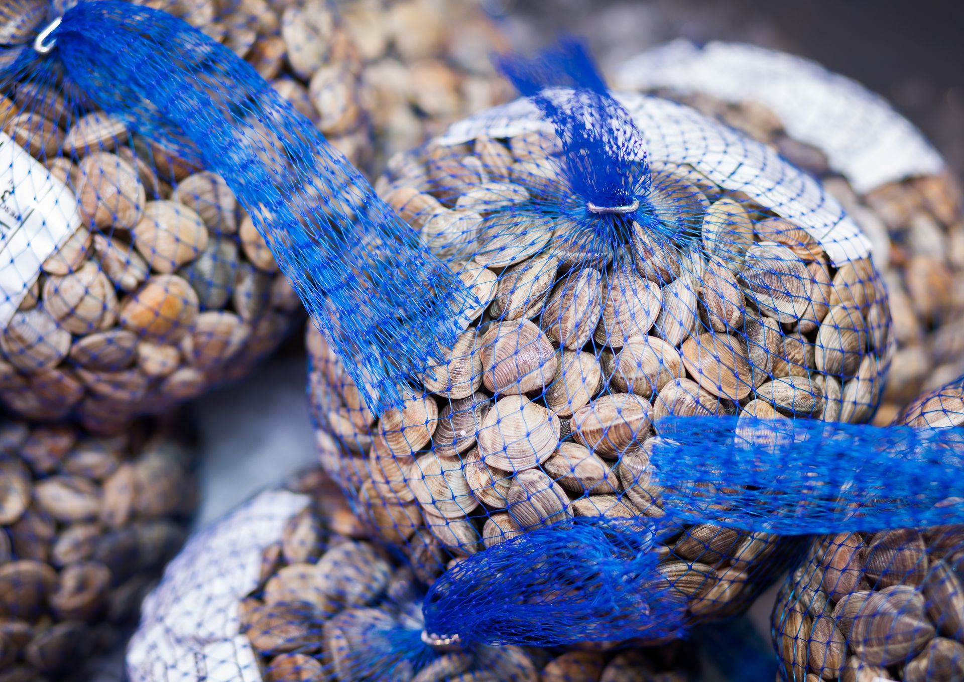 Un montón de bolsas de granos de café están colocadas una encima de otra sobre una mesa.