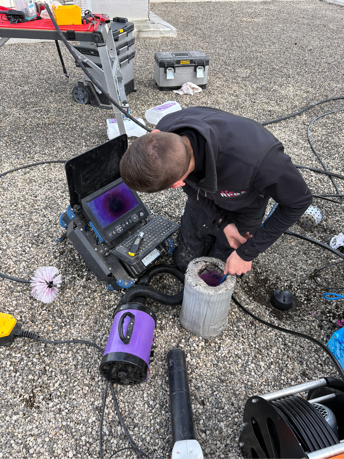 Un homme inspecte du matériel sur un toit.
