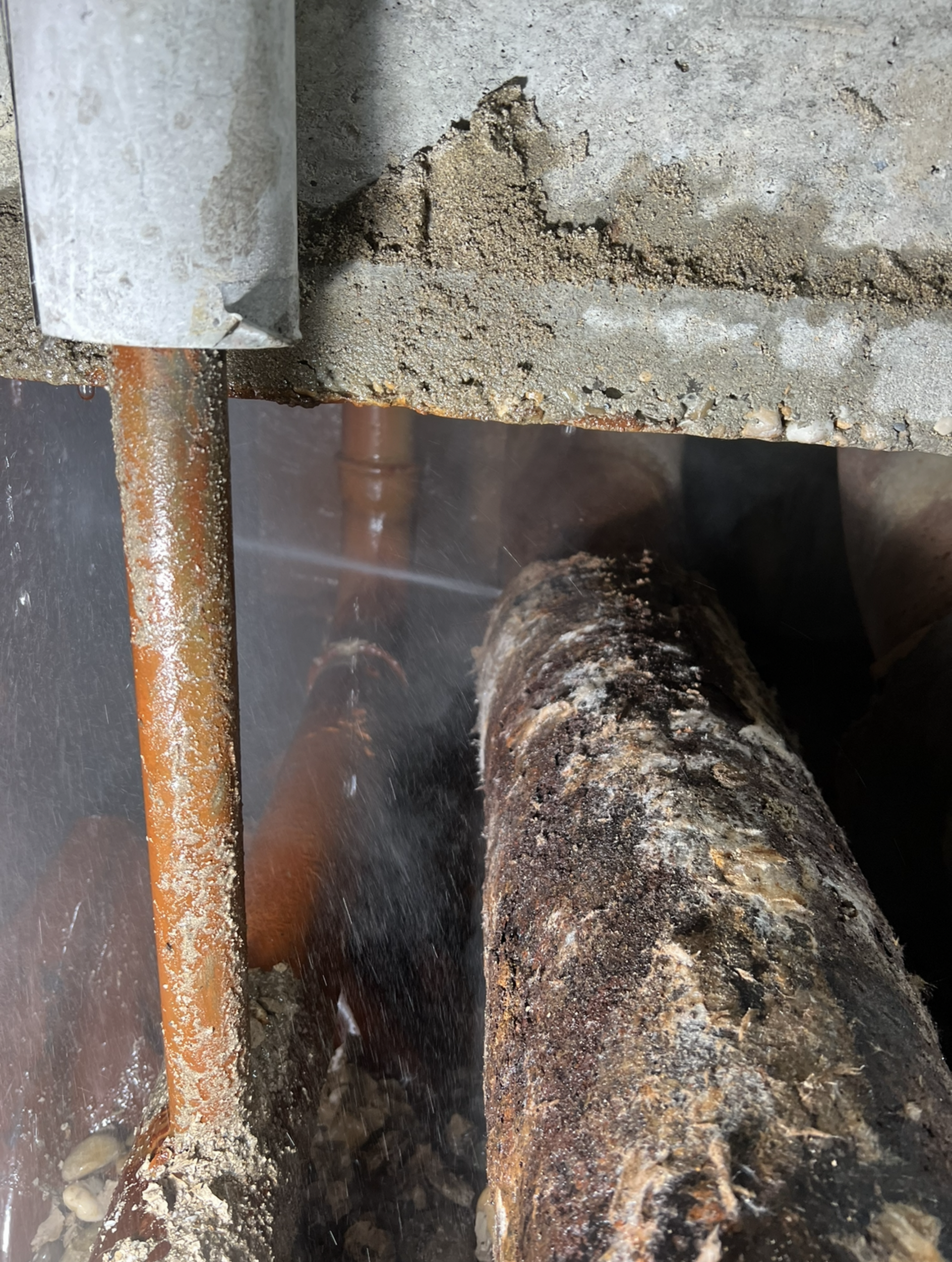 Fuite d'eau due à la rouille près d'une structure en béton.